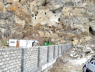 Забор, поставленный впритык к скале. Северная Осетия, Алагирский район, июнь 2012 г. Фото предоставлено Комитетом по охране и использованию объектов культурного наследия Северной Осетии