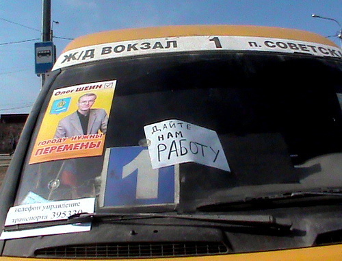 Маршрутное такси с лозунгом бастующих и предвыборным плакатом Олега Шеина. Астрахань, 13 апреля 2012 г. Фото Елены Гребенюк для "Кавказского узла"