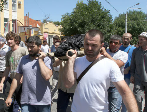 Участники траурного шествия несут тело убитого журналиста Ахмеднаби Ахмеднабиева. Махачкала, 9 июля 2013 г. Фото Руслана Алибекова.