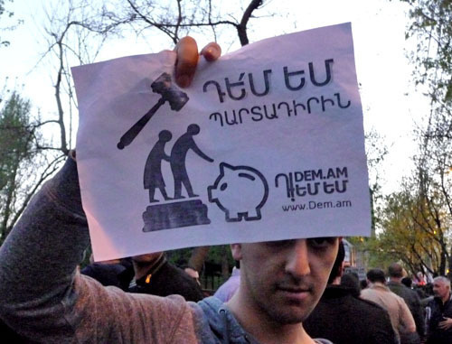 Участник акции против пенсионной реформы держит плакат с надписью "Я против обязательного компонента". Ереван, 18 апреля 2014 г. Фото Армине Мартиросян для "Кавказского узла"