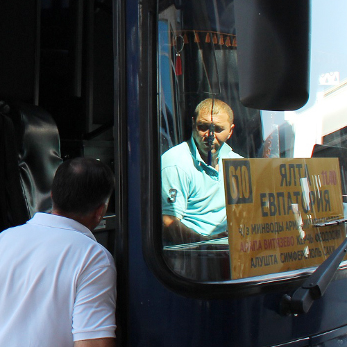 Пассажир разговаривает с водителем автобуса, отправляющегося в Крым с автовокзала №1 Владикавказа. 1 августа 2014 г. Фото Эммы Марзоевой для "Кавказского узла"