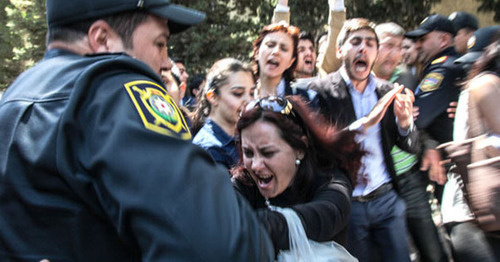 Полицейский задерживает протестующих против вынесения судом обвинительного приговора активистам движения Nida. Баку, 6 мая 2014 г. Фото Азиза Каримова для "Кавказского узла"