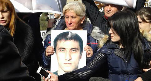 Фото погибшего в руках женщины на митинге возле Дворца правосудия. Фото Александры Кузнецовой для "Кавказского узла"