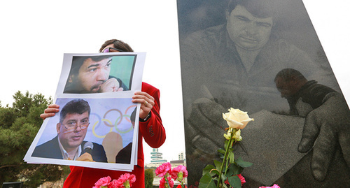 Активист держит в руках плакат с фото Эльмара Гусейнова и российского оппозиционного политика Бориса Немцова. Март 2015 г. Фото Азиза Каримова для "Кавказского узла"