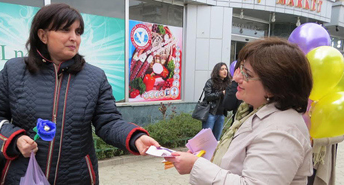 Женщина раздаёт приглашения на  акцию "Женского Ресурсного Центра" в Степанакерте. Фото Алвард Григорян для "Кавказского узла"
