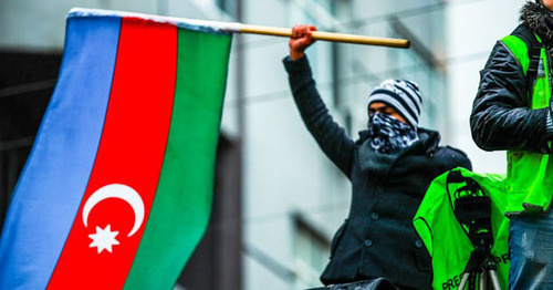 Участник митинга держит в руках флаг Азербайджана. Декабрь 2013 г. Фото Азиза Каримова для "Кавказского узла"