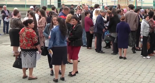 Родственники сдающих экзамен выпускников у одной из школ Карачаево-Черкесии. Скриншот из сюжета телеканала "Архыз 24", YouTube.com