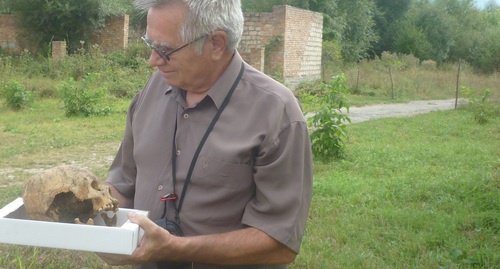 Виктор Котляров держит в руках обнаруженный в некрополе деформированный череп. Фото предоставлено "Кавказскому узлу" Виктором Котляровым. 