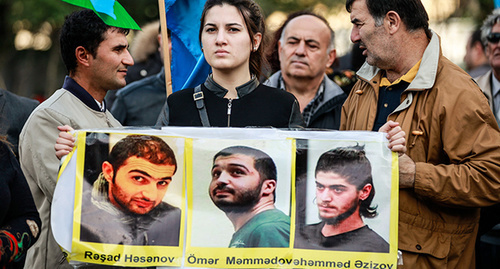 Участница митинга партии "Мусават"  держит в руках  портреты  политзаключенных. Баку, 25 октября 2015 г. Фото Азиза Каримова для "Кавказского узла"