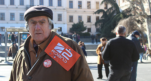 Участник акции в поддержку телекомпании «Рустави-2» держит флажок с логотипом телекомпании. Тбилиси, 19 февраля 2017 г. Фото Инны Кукуджановой для "Кавказского узла"