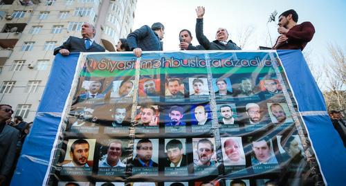 Участник митинга в Баку в апреле 2017 года держит в руках портреты политзаключенных. Фото Азиза Каримова для "Кавказского узла"