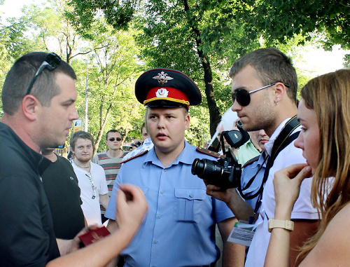 Ведущий специалист отдела энергосбережения департамента городского хозяйства администрации Краснодара Виталий Беляк (слева) требует от участников акции "белых ленточек" покинуть территорию перед краевой администрацией. Краснодар, 20 мая 2012 г. Фото Никиты Серебрянникова для "Кавказского узла"
 