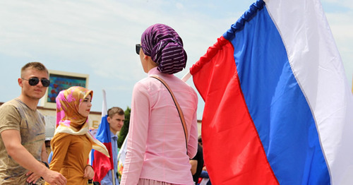 Женщина держит флаг России. Фото Магомеда Магомедова для "Кавказского узла"
