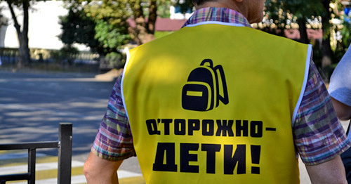 Сотрудник школы № 8 помогает детям переходить на другую сторону улицы. Сочи, 1 сентября 2016 г. Фото Светланы Кравченко для "Кавказского узла" Сотрудник школы № 8 помогает детям переходить на другую сторону улицы. Сочи, 1 сентября 2016 г. Фото Светланы Кравченко для "Кавказского узла"