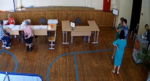 Судя по видеозаписи, члены УИК встали “стеночкой”, загородив от избирателей члена комиссии, вбросившей бюллетени в урну для голосования (в правом углу). Фото: скриншот записи камеры видеонаблюдения на участке №1958 Ростова-на-Дону. Судя по видеозаписи, члены УИК встали “стеночкой”, загородив от избирателей члена комиссии, вбросившей бюллетени в урну для голосования (в правом углу). Фото: скриншот записи камеры видеонаблюдения на участке №1958 Ростова-на-Дону.