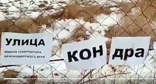 Надпись на заборе вдоль разбитой дороги. Фото: стоп-кадр видео страницы Туподар Краснодар https://twitter.com/typodar Надпись на заборе вдоль разбитой дороги. Фото: стоп-кадр видео страницы Туподар Краснодар https://twitter.com/typodar