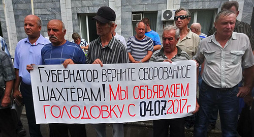 Шахтеры стоят с плакатами возле офиса Кингкоула. Фото Вячеслава Прудникова для "Кавказского узла" Шахтеры стоят с плакатами возле офиса Кингкоула. Фото Вячеслава Прудникова для "Кавказского узла"