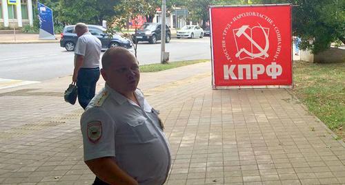 Сотрудник полиции на фоне символики КПРФ. Фото Светланы Кравченко для "Кавказского узла" Сотрудник полиции на фоне символики КПРФ. Фото Светланы Кравченко для "Кавказского узла"