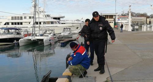 Полицейский и рыбак на причале морпорта Сочи. Фото Светланы Кравченко для "Кавказского узла". Полицейский и рыбак на причале морпорта Сочи. Фото Светланы Кравченко для "Кавказского узла".