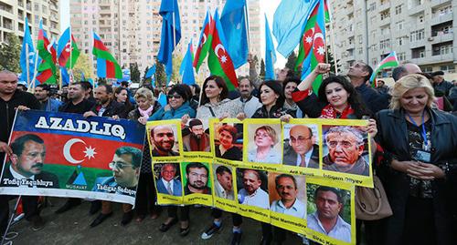 Участники митинга держат в руках плакаты с изображениями политзаключенных. Баку, 25 октября 2015 года. Фото Азиза Каримова для "Кавказского узла" Участники митинга держат в руках плакаты с изображениями политзаключенных. Баку, 25 октября 2015 года. Фото Азиза Каримова для "Кавказского узла"