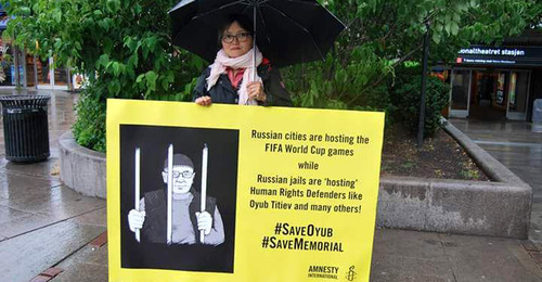 Активисты Amnesty International устроили акцию в поддержку Оюба. На плакатах надпись: "Российские города принимают матчи ЧМ по футболу, а российские тюрьмы "принимают" правозащитников, таких как Оюб Титиев и многие другие". 14 июня 2018 г. Фото: Пресс-служба ПЦ "Мемориал" Активисты Amnesty International устроили акцию в поддержку Оюба. На плакатах надпись: "Российские города принимают матчи ЧМ по футболу, а российские тюрьмы "принимают" правозащитников, таких как Оюб Титиев и многие другие". 14 июня 2018 г. Фото: Пресс-служба ПЦ "Мемориал"