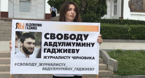 Журналист "Черновика" Инна Хатукаева держит плакат с портретом Абдулмумина Гаджиева. Фото Патимат Махмудовой для "Кавказского узла" Журналист "Черновика" Инна Хатукаева держит плакат с портретом Абдулмумина Гаджиева. Фото Патимат Махмудовой для "Кавказского узла"