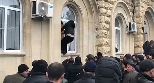 Участник митинга пытается залезть в окно здания администрации президента и парламента Абхазии. Скриншот видео штурма здания администрации президента Абхазии 9 января 2020 года. https://web.telegram.org/#/im?p=@SputnikAbkhazia Участник митинга пытается залезть в окно здания администрации президента и парламента Абхазии. Скриншот видео штурма здания администрации президента Абхазии 9 января 2020 года. https://web.telegram.org/#/im?p=@SputnikAbkhazia
