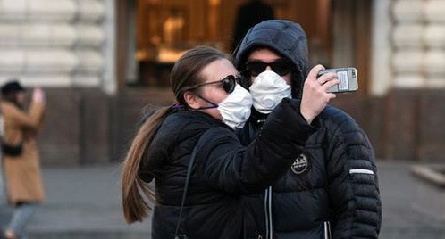 Прохожие в медицинский масках. REUTERS/Evgenia Novozhenina Прохожие в медицинский масках. REUTERS/Evgenia Novozhenina