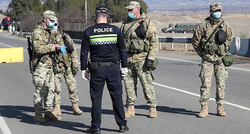 Грузинские военнослужащие и полицейский в защитных масках стоят на страже на контрольно-пропускном пункте. Грузия, Марнеули, март 2020 г. Фото: REUTERS/Irakli Gedenidze Грузинские военнослужащие и полицейский в защитных масках стоят на страже на контрольно-пропускном пункте. Грузия, Марнеули, март 2020 г. Фото: REUTERS/Irakli Gedenidze