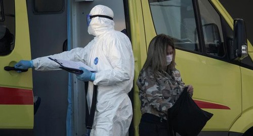 Медицинский работник в защитном костюме и пациент в защитной маске возле машины скорой помощи. Россия, апрель 2020 года. Фото: REUTERS/Tatyana Makeyeva Медицинский работник в защитном костюме и пациент в защитной маске возле машины скорой помощи. Россия, апрель 2020 года. Фото: REUTERS/Tatyana Makeyeva
