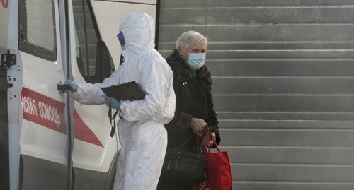 Медицинский работник в защитном костюме с пациентом. Фото: REUTERS/Tatyana Makeyeva Медицинский работник в защитном костюме с пациентом. Фото: REUTERS/Tatyana Makeyeva