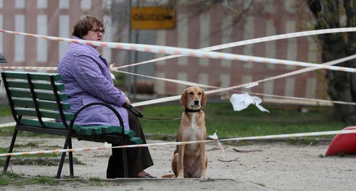 Женщина гуляет с собакой во дворе дома. Фото: REUTERS/Evgenia Novozhenina Женщина гуляет с собакой во дворе дома. Фото: REUTERS/Evgenia Novozhenina