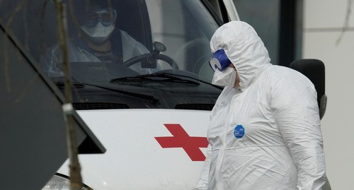 Медицинский сотрудник в защитном костюме возле машины скорой помощи. Фото: REUTERS/Tatyana Makeyeva Медицинский сотрудник в защитном костюме возле машины скорой помощи. Фото: REUTERS/Tatyana Makeyeva