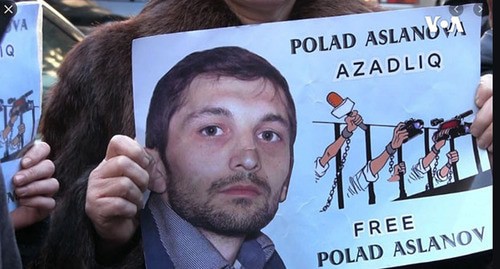 Участник акции держит плакат изображением Полада Асланова. Скриншот видео "
Amerikanın Səsi" https://www.youtube.com/watch?v=MeItCVwfF20 Участник акции держит плакат изображением Полада Асланова. Скриншот видео "
Amerikanın Səsi" https://www.youtube.com/watch?v=MeItCVwfF20