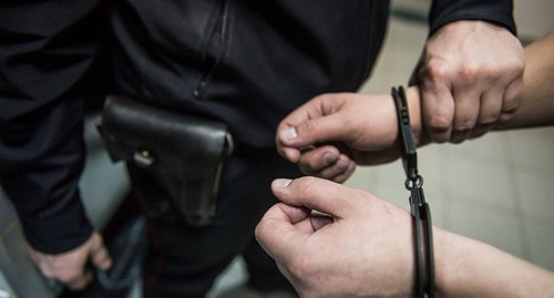 Сотрудник полиции надевает наручники на подозреваемого. Фото: Елена Синеок, Юга.ру Сотрудник полиции надевает наручники на подозреваемого. Фото: Елена Синеок, Юга.ру