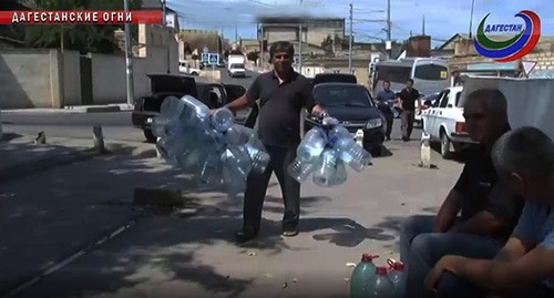 Жители Дагестанских огней с пластиковыми бутылками для питьевой воды. Иллюстративное фото. Скриншот видео https://www.rgvktv.ru/obshchestvo/60898 Жители Дагестанских огней с пластиковыми бутылками для питьевой воды. Иллюстративное фото. Скриншот видео https://www.rgvktv.ru/obshchestvo/60898