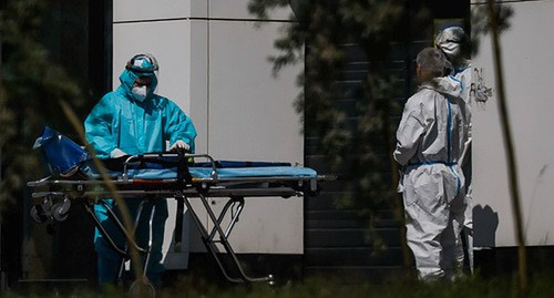 Медицинские работники в защитных костюмах. Фото: REUTERS/Максим Шеметов Медицинские работники в защитных костюмах. Фото: REUTERS/Максим Шеметов