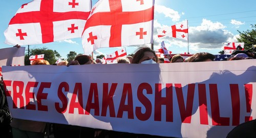 Сторонники Михаила Саакашвили с плакатом и флагами Грузии. 4 октября 2021 года. Фото: REUTERS/Irakli Gedenidze Сторонники Михаила Саакашвили с плакатом и флагами Грузии. 4 октября 2021 года. Фото: REUTERS/Irakli Gedenidze