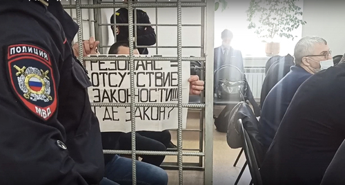 Плакат обвиняемого в зале суда. Кадр видео: объединенная пресс-служба судов Волгоградской области Плакат обвиняемого в зале суда. Кадр видео: объединенная пресс-служба судов Волгоградской области
