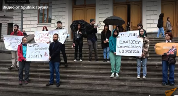 Акция протеста студентов Тбилисского государственного университета. Май 2022 года. Скриншот видео https://sputnik-georgia.ru/20220502/tbilisskie-studenty-proveli-aktsiyu-protesta-u-zdaniya-tgu---video-266375980.html Акция протеста студентов Тбилисского государственного университета. Май 2022 года. Скриншот видео https://sputnik-georgia.ru/20220502/tbilisskie-studenty-proveli-aktsiyu-protesta-u-zdaniya-tgu---video-266375980.html