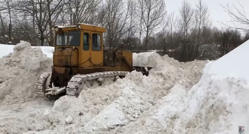 Водитель бульдозера расчищает дорогу после снегопада. Стопкадр из видео https://www.youtube.com/watch?v=Fe9qu-qUVH8 Водитель бульдозера расчищает дорогу после снегопада. Стопкадр из видео https://www.youtube.com/watch?v=Fe9qu-qUVH8