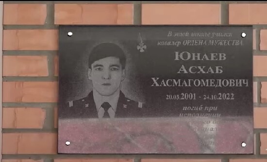 Мемориальная доска в честь Асхаба Юнаева. Стоп-кадр видео из YouTube-канала ЧГТРК "Грозный" от 11.03.23, https://www.youtube.com/watch?v=UgHq6ipVmIE Мемориальная доска в честь Асхаба Юнаева. Стоп-кадр видео из YouTube-канала ЧГТРК "Грозный" от 11.03.23, https://www.youtube.com/watch?v=UgHq6ipVmIE