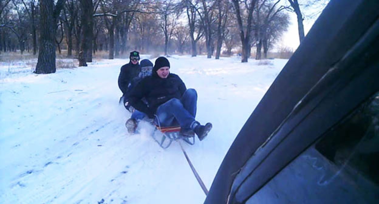 Автомобилист катает людей на санках, привязав их к машине. Скриншот видео https://www.youtube.com/watch?v=S0hyRVl9tAA