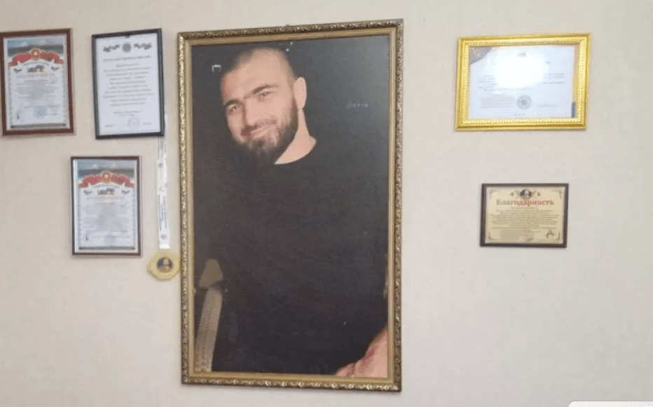 Фотография Курбана Далгатова в доме его родителей. Фото: "Черновик", https://chernovik.net/news/zakryl-kurtkoy-obzor-videokamery-i-telo-kurbana-potaschili-vniz Фотография Курбана Далгатова в доме его родителей. Фото: "Черновик", https://chernovik.net/news/zakryl-kurtkoy-obzor-videokamery-i-telo-kurbana-potaschili-vniz