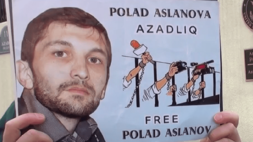 Плакат с требованием освободить Полада Асланова. Стоп-кадр видео из YouTube-канала Turan от 03.03.21, https://www.youtube.com/watch?v=DQMo-1lRtUY Плакат с требованием освободить Полада Асланова. Стоп-кадр видео из YouTube-канала Turan от 03.03.21, https://www.youtube.com/watch?v=DQMo-1lRtUY