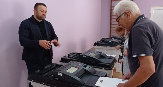 Председатель Центральной избирательной комиссии Георгий Каладаришвили объясняет избирателям процедуру электронного голосования. Тбилиси, 6 июля 2024 года. Фото Инны Кукуджановой для "Кавказского узла". Председатель Центральной избирательной комиссии Георгий Каладаришвили объясняет избирателям процедуру электронного голосования. Тбилиси, 6 июля 2024 года. Фото Инны Кукуджановой для "Кавказского узла".