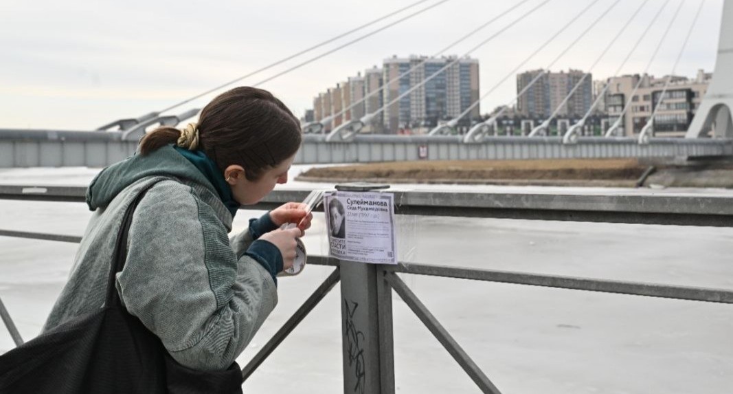 Елена Патяева наклеивает листовку на перила моста. Санкт-Петербург, 8 марта 2025 года. Фото из телеграм-канала Елены Патяевой https://t.me/helpseda/313 Елена Патяева наклеивает листовку на перила моста. Санкт-Петербург, 8 марта 2025 года. Фото из телеграм-канала Елены Патяевой https://t.me/helpseda/313