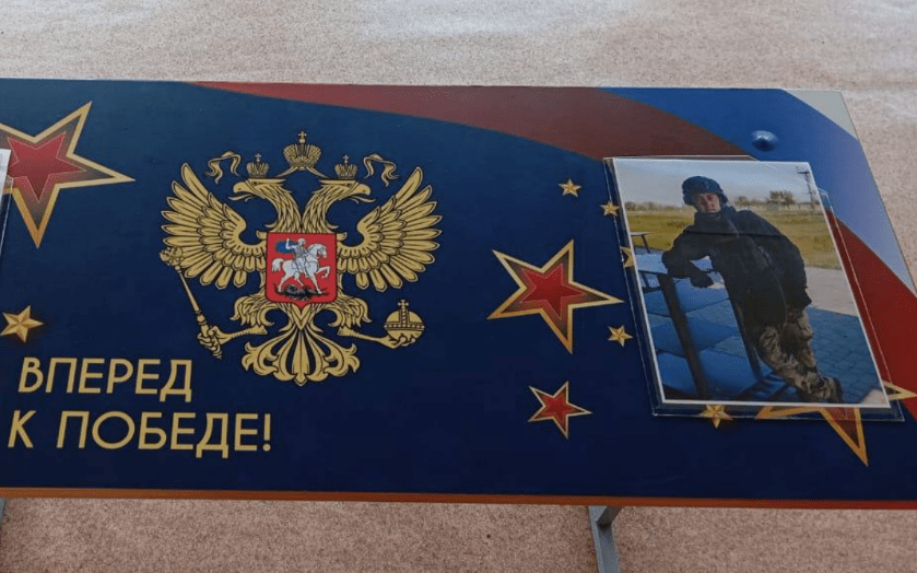 Именная парта в память о Максиме Новгородцеве. Скриншот фото из Telegram-канала Михаила Миненкова от 22.05.25, https://t.me/maMinenkov/35821?single. Именная парта в память о Максиме Новгородцеве. Скриншот фото из Telegram-канала Михаила Миненкова от 22.05.25, https://t.me/maMinenkov/35821?single.