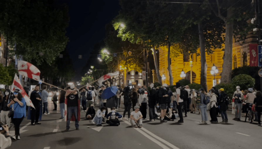 Активисты заблокировали движение у театра оперы и балета. Скриншот фото телекомпании "Пирвели" от 24.05.25, https://tvpirveli.ge/ka/siaxleebi/politika/101879-politsiam-rustaveli-chaketa-aqtivistebma-operis-tsin-gadainatsvles.