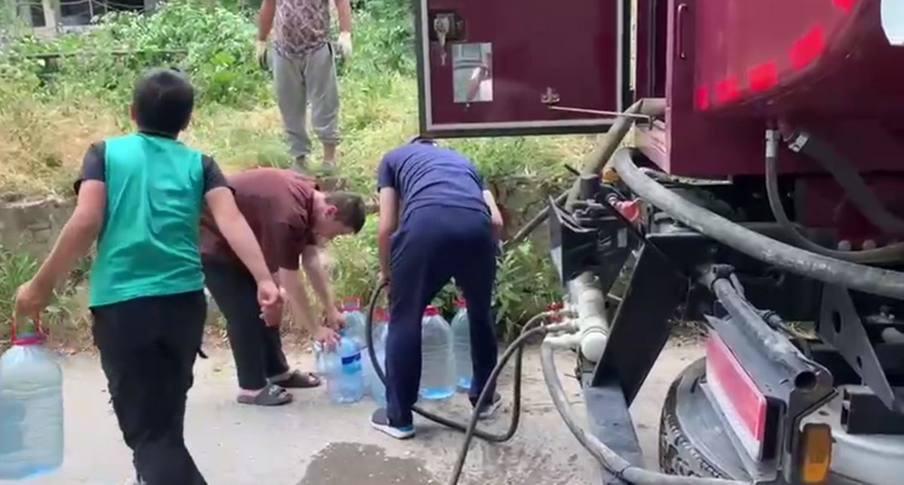 Люди набирают воду из водовоза. Кадр видео из телеграм-канала администрации Буйнакска https://t.me/gorodbuynaksk/8092 Люди набирают воду из водовоза. Кадр видео из телеграм-канала администрации Буйнакска https://t.me/gorodbuynaksk/8092